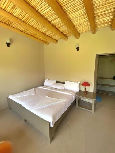 a bedroom with a large bed and a table at Lharje Resort in Satti