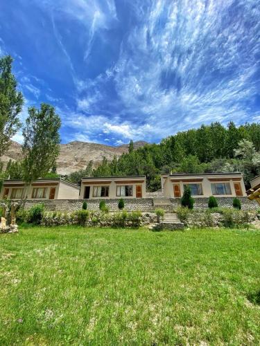 a large house with a grass field in front of it at Lharje Resort in Satti
