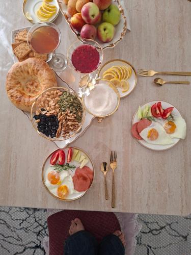 a table topped with plates of food and fruit at Guest house USMAN in Kazarman