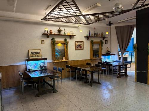 a restaurant with tables and chairs and a fish tank on the wall at Narva Center Aparthotel in Narva