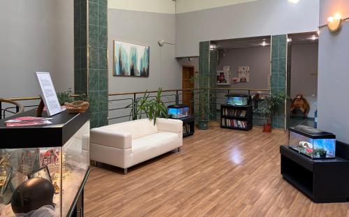 a living room with a white couch and a tv at Narva Center Aparthotel in Narva