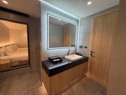 ein Badezimmer mit Waschbecken und Spiegel in der Unterkunft Mehtan Hotel in Mae Sot