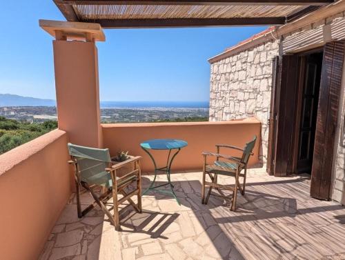 a patio with chairs and a table on a balcony at Fyllosia Villa Part of Cretan Retreat in Archanes