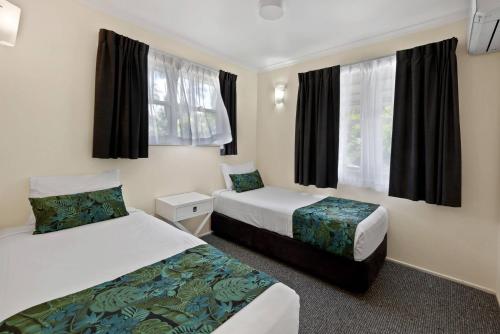 a hotel room with two beds and a window at Comfort Resort Blue Pacific in Mackay