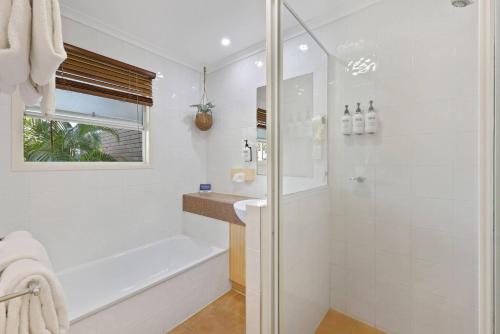 a white bathroom with a shower and a sink at Comfort Resort Blue Pacific in Mackay