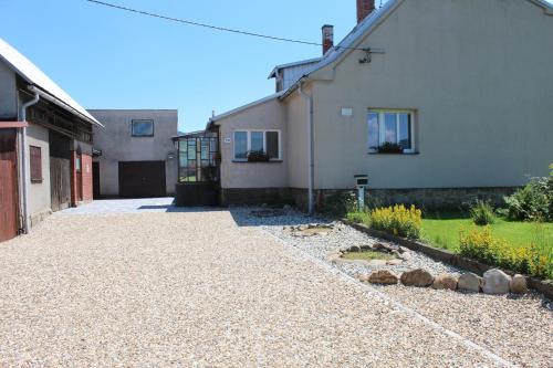 an empty driveway next to a white house at Chalupa pod Lysou horou in Ostravice
