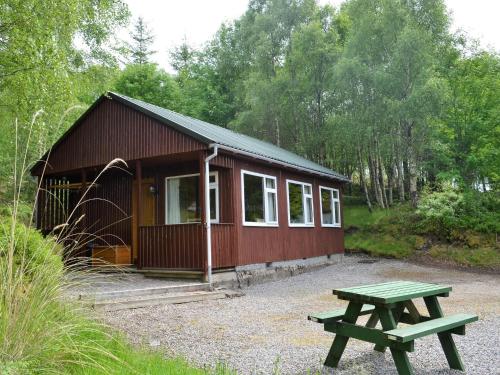 a small cabin with a picnic table in front of it at Faichemard Farm Chalets in Invergarry