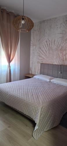 a bedroom with a large bed and a chandelier at Via Roma Residence in Maniago