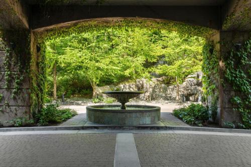 a stone archway with a fountain in a park at DoubleTree by Hilton North Vancouver in North Vancouver