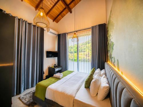 a bedroom with a bed with a large window at The cloud ella in Ella