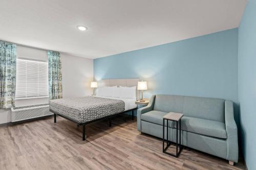 a bedroom with a couch and a bed and a couch and a chair at WoodSpring Suites Atlanta Canton in Canton