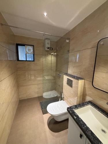 a bathroom with a toilet and a sink and a mirror at Hotel Anan Palace in Ābu Road
