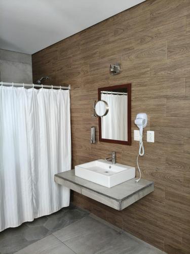 a bathroom with a white sink and a mirror at Hotel Guivá Aeropuerto in Oaxaca City