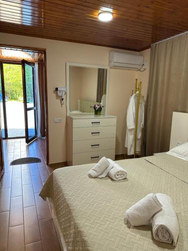 a bedroom with a bed with two towels on it at RIVERSIDE Cottage in Martvili