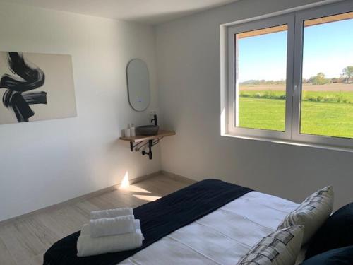 a white room with a bed and a window at Villa Houtave in Zuienkerke