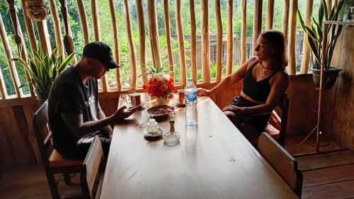 a man and a woman sitting at a table at Komachi House in Limbung