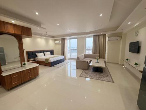 a large living room with a bed and a television at Hotel Mikado Palace in Gurgaon