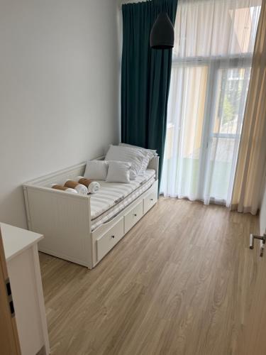 a white bed in a room with a window at Silver Side Apartments in Siófok