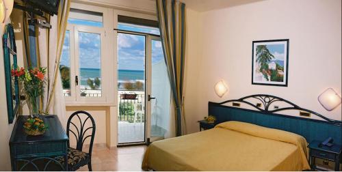 a bedroom with a bed and a view of the ocean at Villa Gaia Hotel in Cefalù