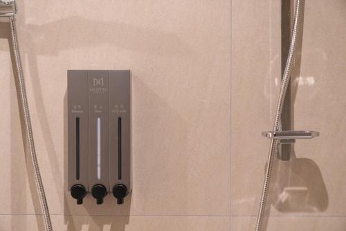 eine Fernbedienung in einer Schachtel in der Dusche in der Unterkunft MH Hotel 2 in Jeonju