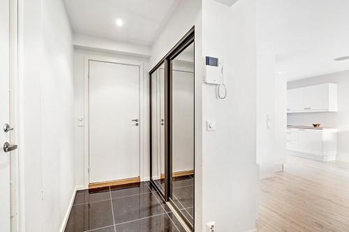 a hallway with white walls and a mirror at Engen Apartment in Bergen