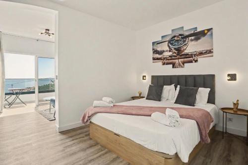a bedroom with a large bed and a balcony at Lobo's House in Câmara de Lobos