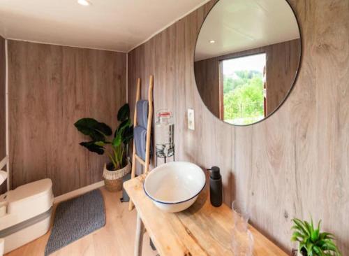 a bathroom with a large mirror and a wooden table at Entre Ciel et Rivière in Bouillon