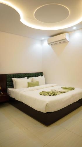 a bedroom with a large bed with a ceiling at Sylhet Regency Ltd in Sylhet