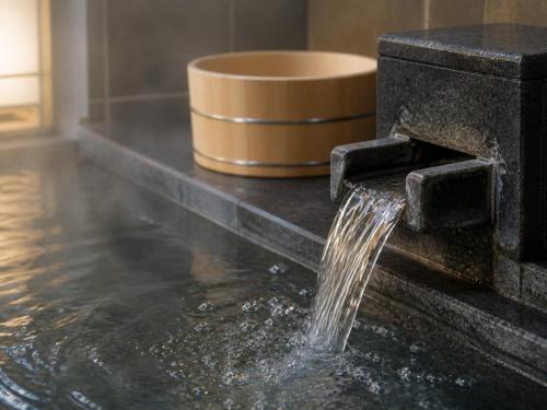 a water fountain in the middle of a bathroom at Shirahama Onsen Kisyu Hanto in Shirahama