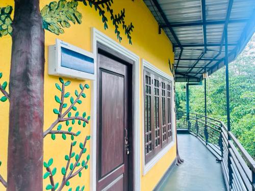 a yellow building with a door and a balcony at K K Kumar Guest in Norwood