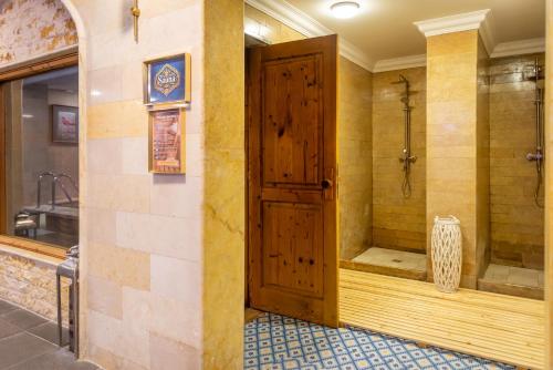 a bathroom with a shower with a wooden door at Phoenicia Express Hotel in Bucharest