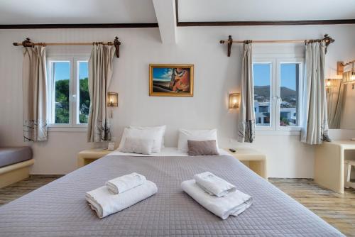 a bedroom with a large bed with two towels on it at Crystal Dream Paros in Kampos Paros