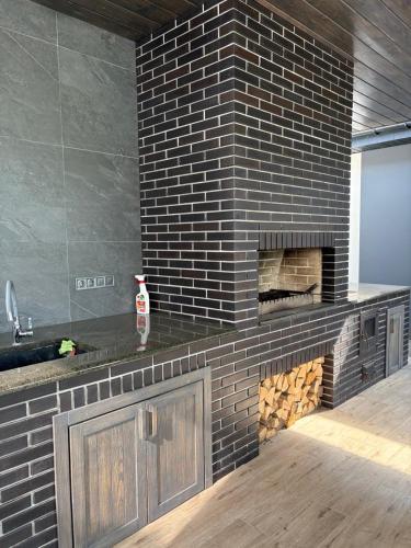 a brick wall with a fireplace in a room at Relax Lux in Mykolaivka