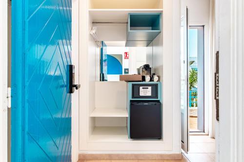 a blue door leading into a kitchen with a dishwasher at Smart Hotel Cabo Sur in Mojácar