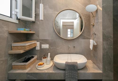 a bathroom with a sink and a mirror at Petali Village Hotel in Apollonia