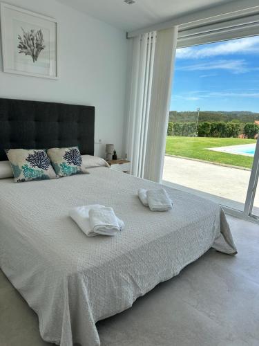 a bedroom with a large bed with two towels on it at Villa Cariño - Apartamento en Malpica de Bergantiños in Malpica