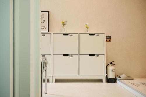 a white cabinet with four doors in a room at 쉼스테이 in Myŏnghag-yŏk