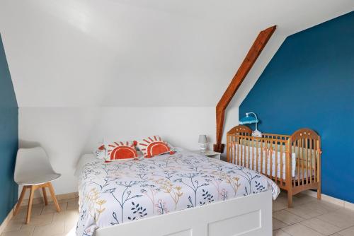 a bedroom with a crib and a blue wall at Le Karush proche chambord in Mer