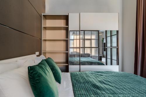 a bedroom with a bed and a large mirror at Lumina I Comfy Loft with Parking I View of the Lake in Łódź