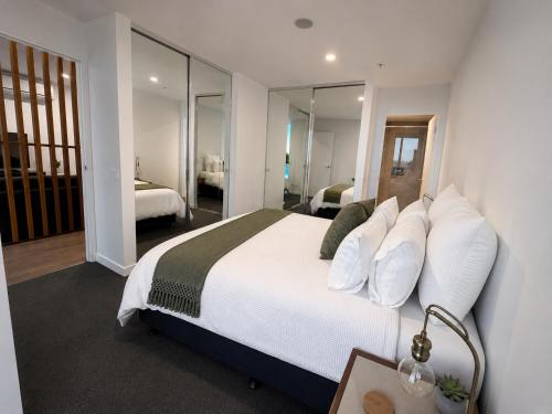 a bedroom with a large bed with white pillows at Rise to the top! in Melbourne