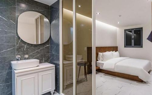 a bathroom with a bed and a sink and a mirror at Hotel Seven Step in Incheon