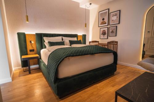 a bedroom with a large bed with a green headboard at Hotel zum Kaiserdom in Speyer
