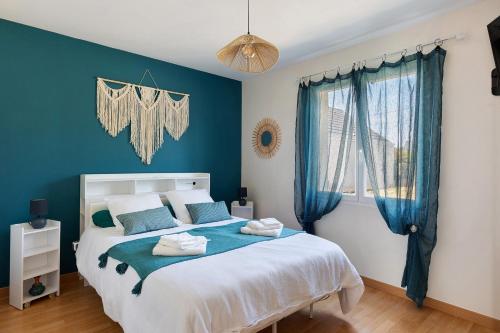 a bedroom with a large bed with blue walls at Le Refuge des deux Cœurs - Beauval in Villefranche-Sur-Cher