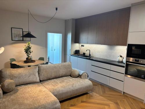 a living room with a couch and a kitchen at APARTMENT A&D Monaco in Poprad