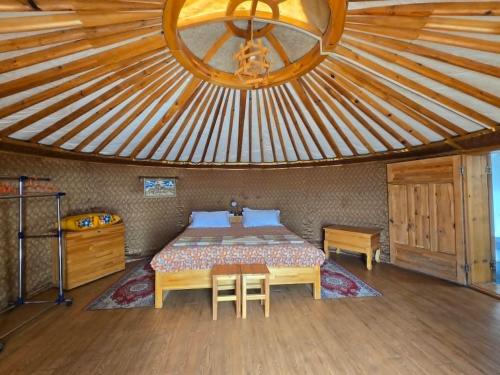 a bedroom with a bed in a room with a ceiling at Gobi Sun Lodge in Hushuu Hural