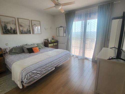 a bedroom with a bed and a large window at Bellavista in Piedralaves