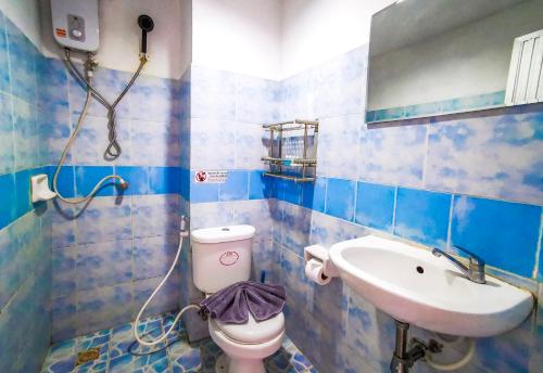 a blue tiled bathroom with a toilet and a sink at Patong Canal Villa 208 in Patong Beach