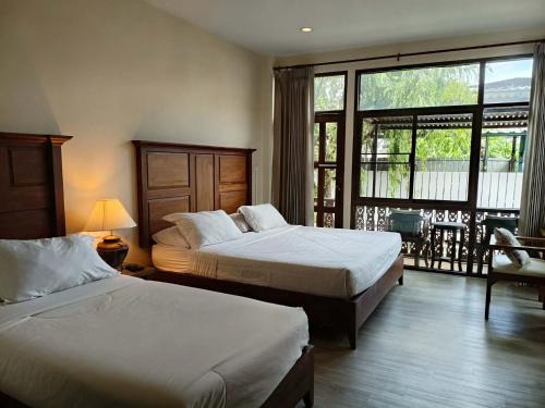 a hotel room with two beds and a balcony at Mountain View GuesthouseChiangmai in Chiang Mai