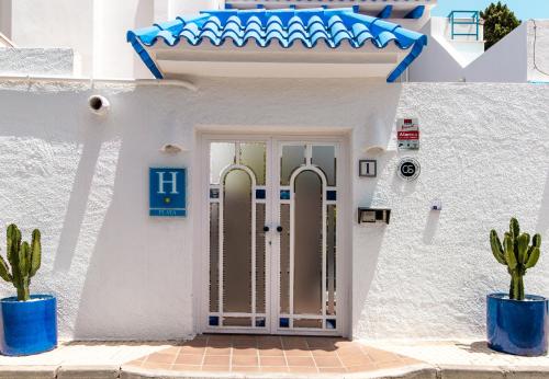 a white house with a door and cactus at Smart Hotel Cabo Sur in Mojácar