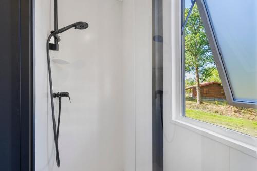 a shower in a bathroom with a window at Mobilehome Vallon 57 in Saint-Gervais
